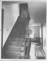 SA0516 - Photo shows a stairway, hall, table, chair, and rugs.